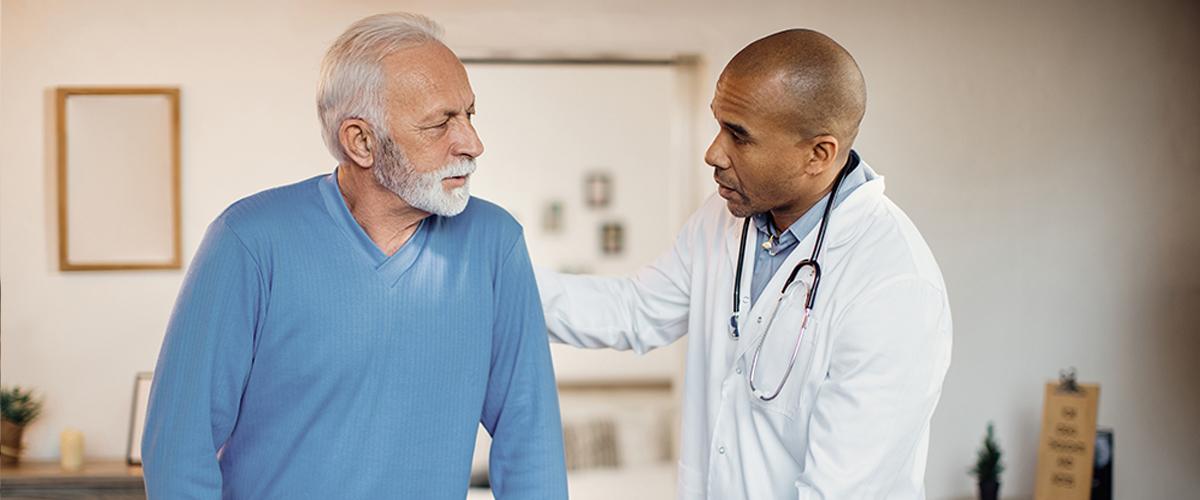 African American doctor assisting a caucasian senior male.